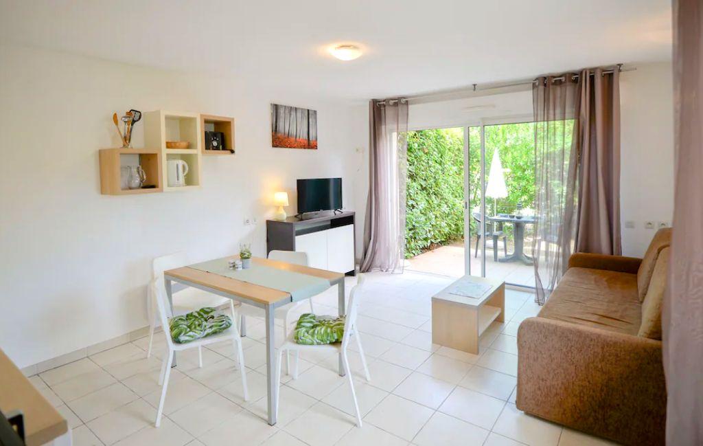 Slide Bright living room opening onto a terrace in an apartment at Château de Jouarres in Azille
