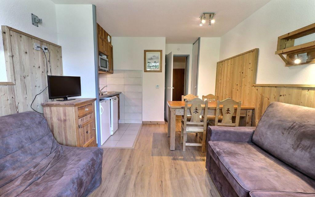Slide Overall view of the living room with lounge and dining area in the Grands Bois residence in La Tania Courchevel