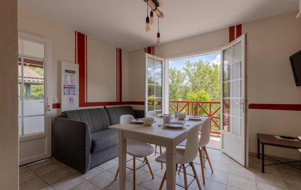 Slide Séjour d’un appartement pour 4 personnes avec canapé et table à manger aux collines iduki