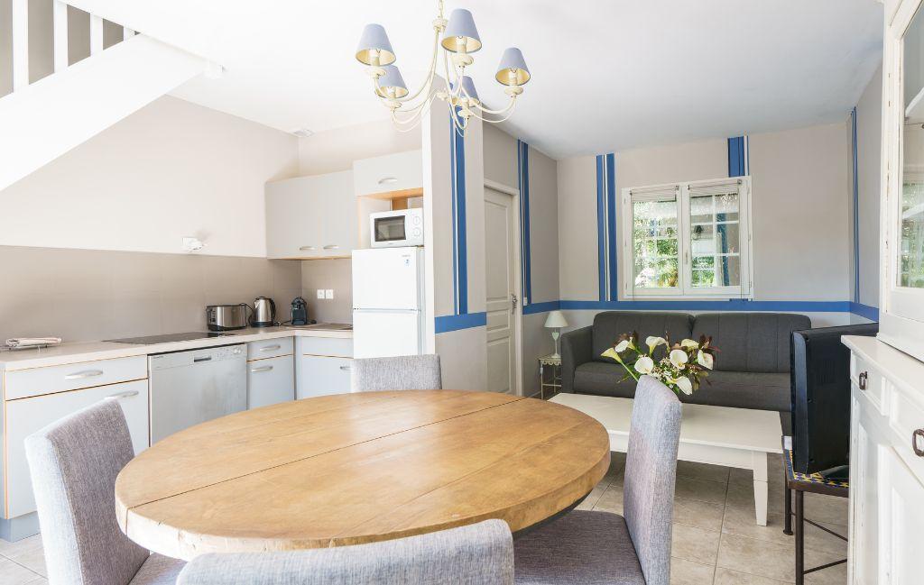 Slide Vue d’ensemble d’un séjour composé d’une cuisine ouverte, salon et table à manger au sein d’un appartement pour 6 personnes aux collines iduki