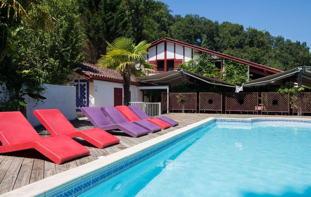 Slide Swimming pool with colourful sun loungers at Les Collines Iduki residence