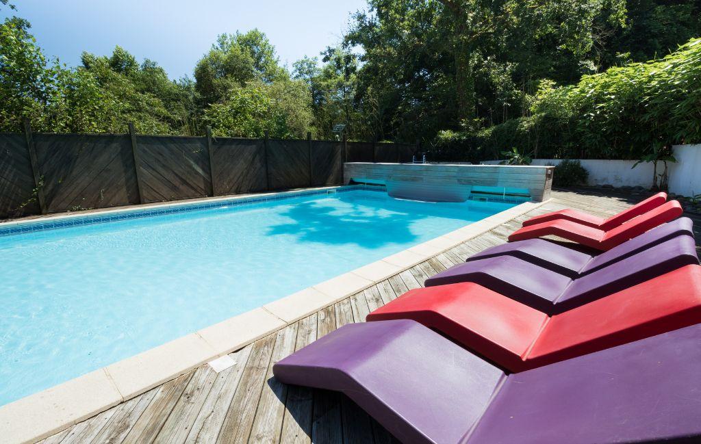Slide Horizontal view of the heated swimming pool at Les Collines Iduki with sun loungers