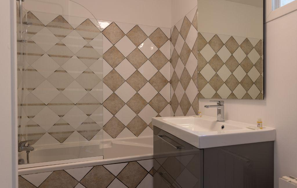 Slide Bathroom with bathtub and sink in a 4-person apartment at Les Collines Iduki