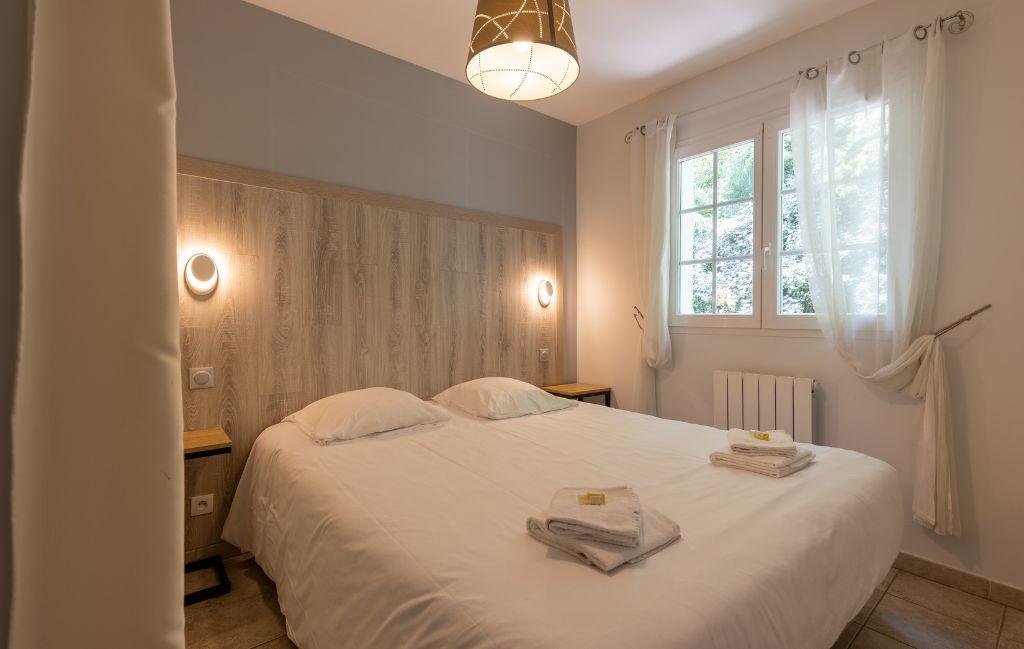 Slide Double bedroom with window overlooking the outside in the Iduki Hills