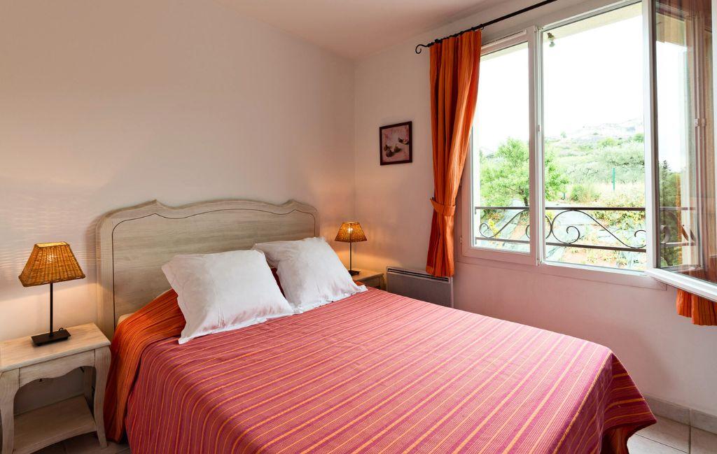 Slide Bedroom with a double bed for two people and a view of the green spaces at the Bourgeac estate