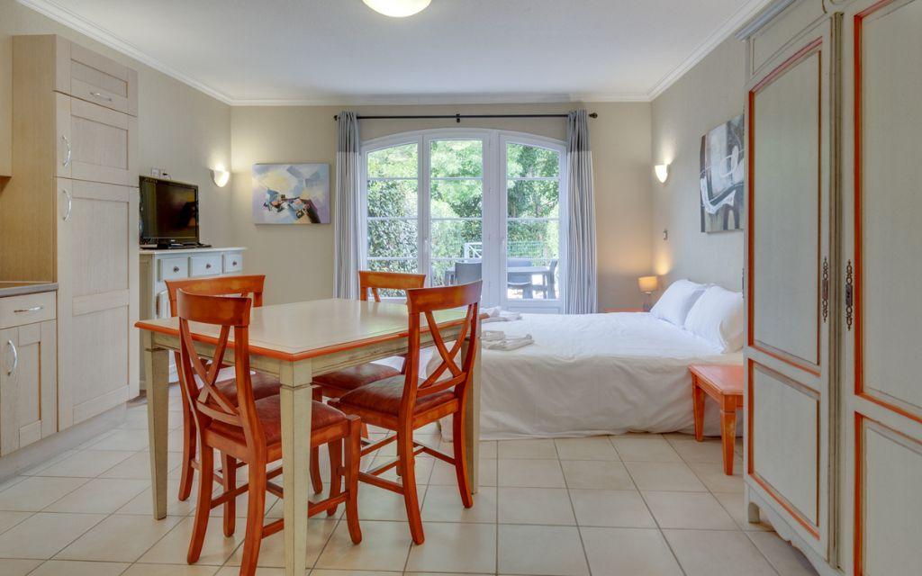 Slide Studio pour deux personnes avec séjour et lit en fond au Domaine de Camiole