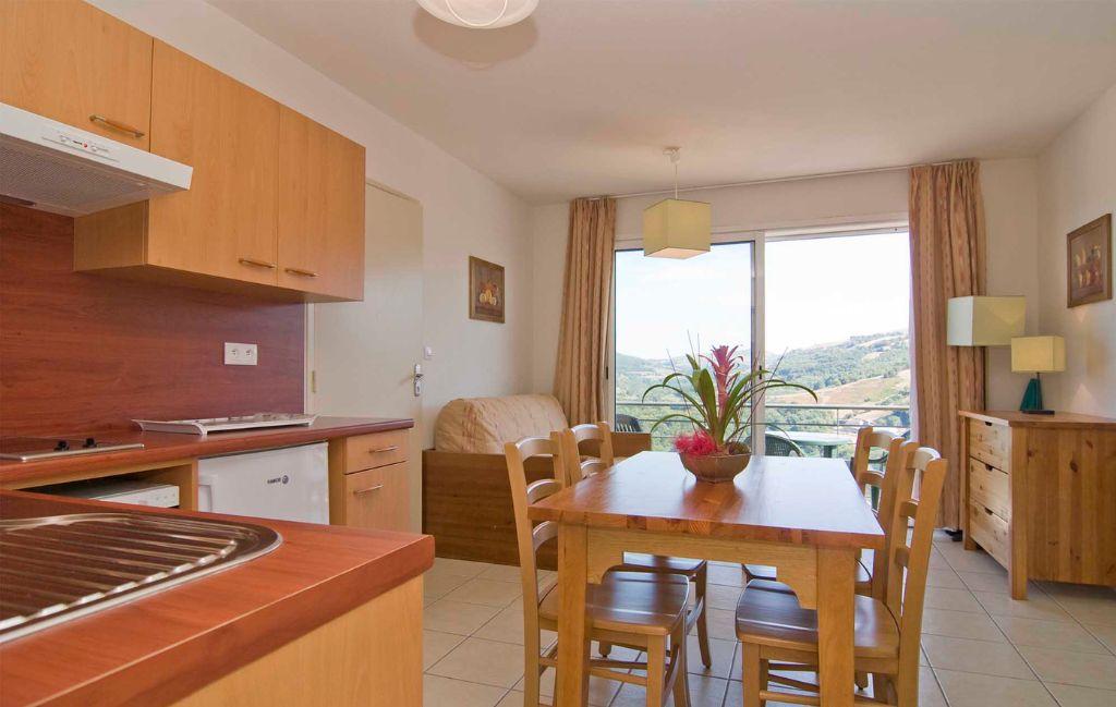 Slide Overall view of the living area with open-plan kitchen and lounge in an apartment at La Marquisié