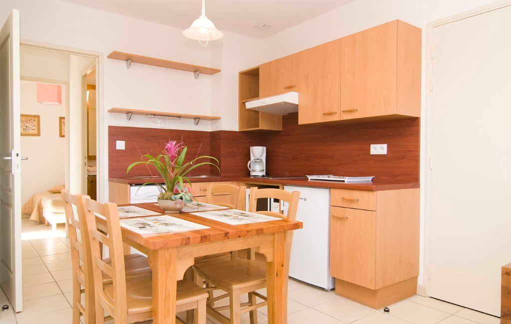 Slide Equipped open kitchen with dining area in an apartment at La Marquisié