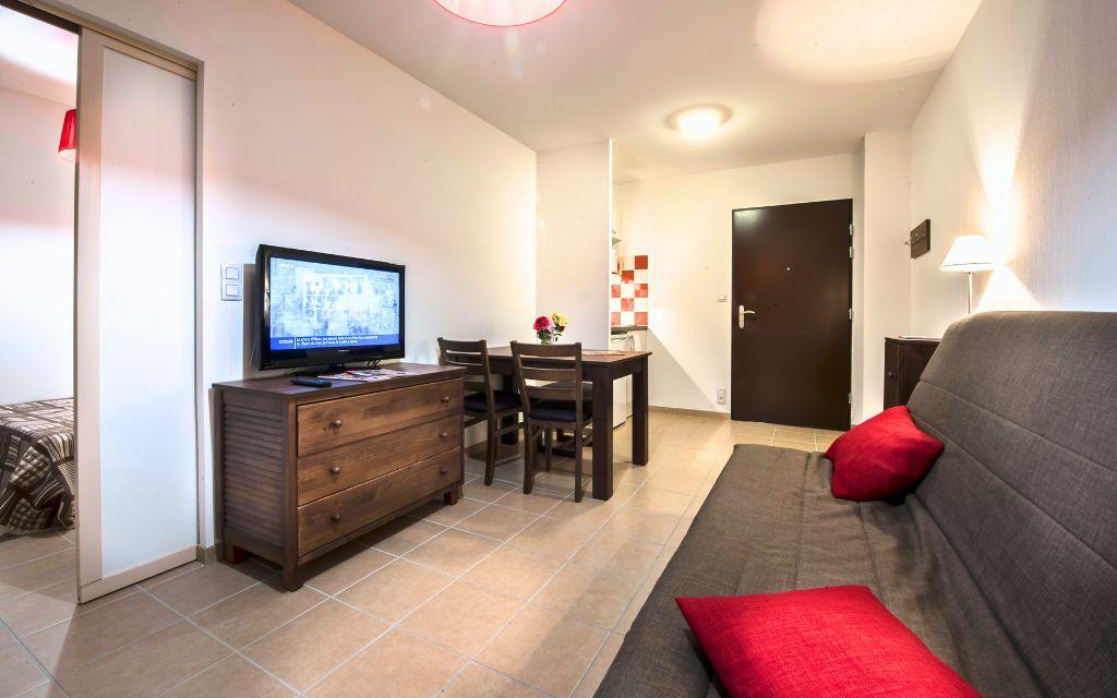 Slide Lounge with sofa bed and television in an apartment at Résidence Le Clos du Rocher in Dordogne