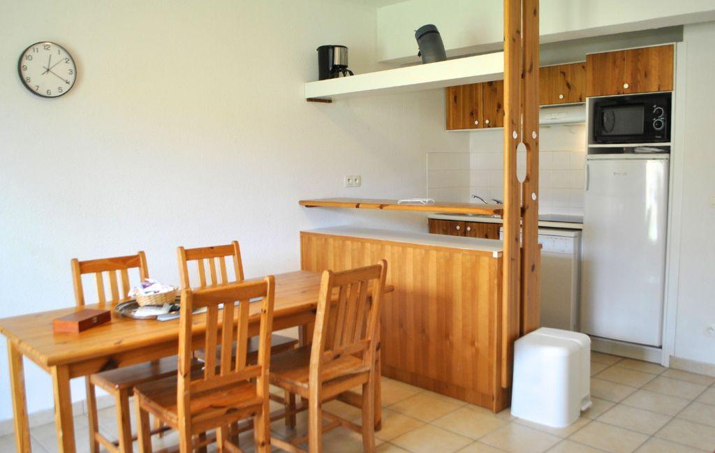 Slide Fully equipped kitchen area with dining space in one of the accommodations at Le Hameau des Sources in Montbrun-les-Bains