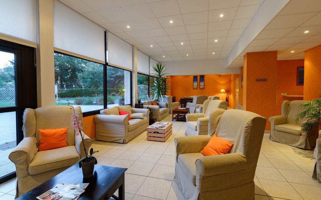 Slide Lounge area with sofas at the reception of Résidence Les Roches Douvres