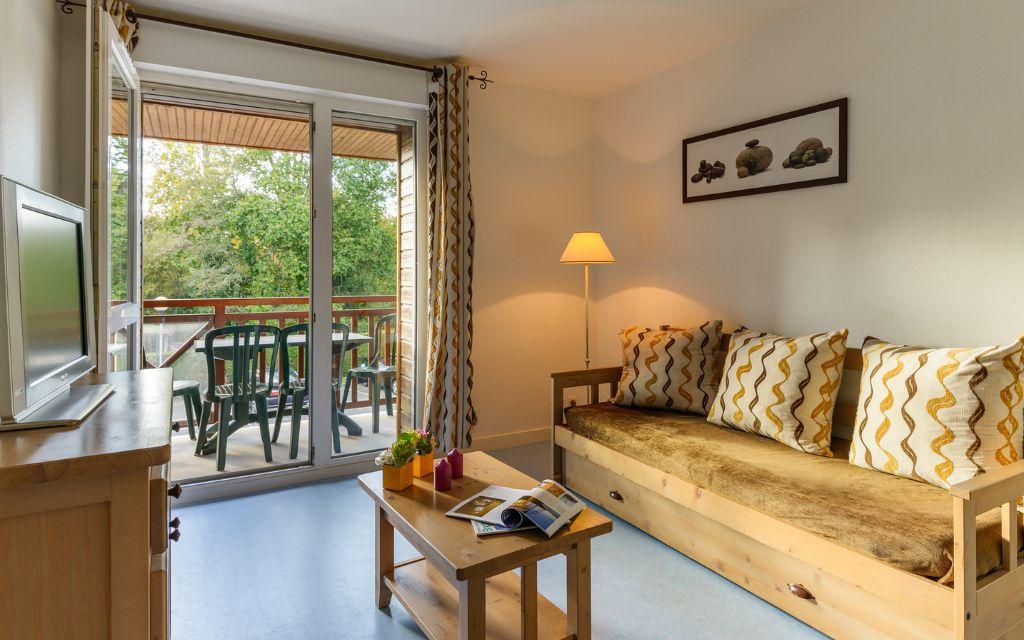 Slide Living room with sofa bed, television and outdoor access in an apartment at Résidence Les Roches Douvres