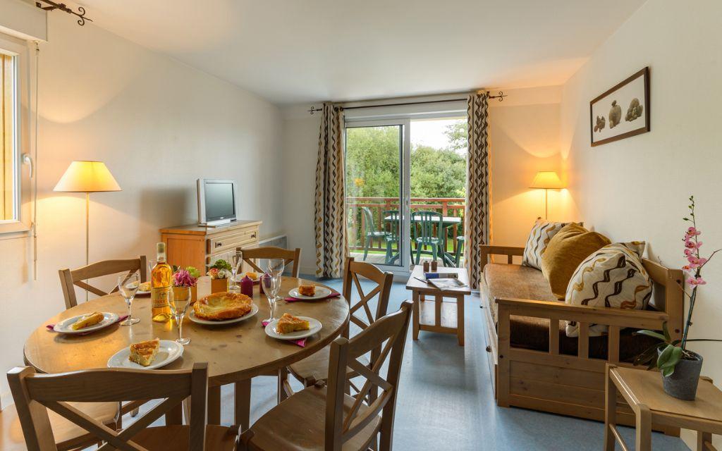 Slide Living area with dining space and lounge in an apartment at Résidence Les Roches Douvres