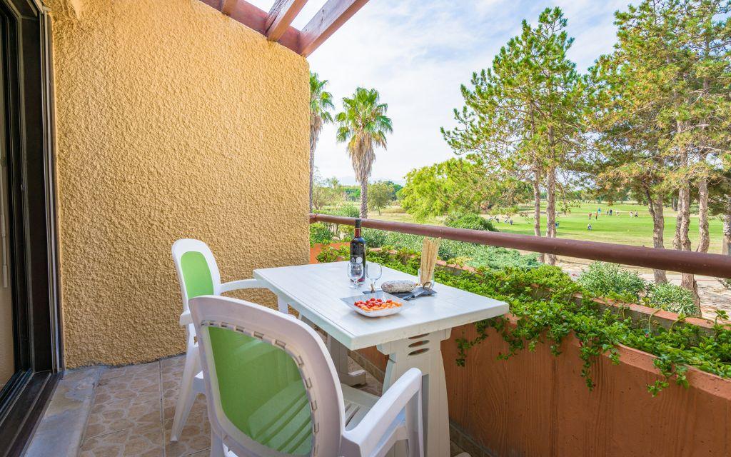 Slide Balcony with a view of the green surroundings of Résidence du Golf in Saint-Cyprien-Plage