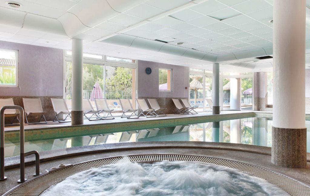 Slide Relaxation area with hot tubs and indoor pool at the La Licorne de Haute-Provence residence in Gréoux-les-Bains.