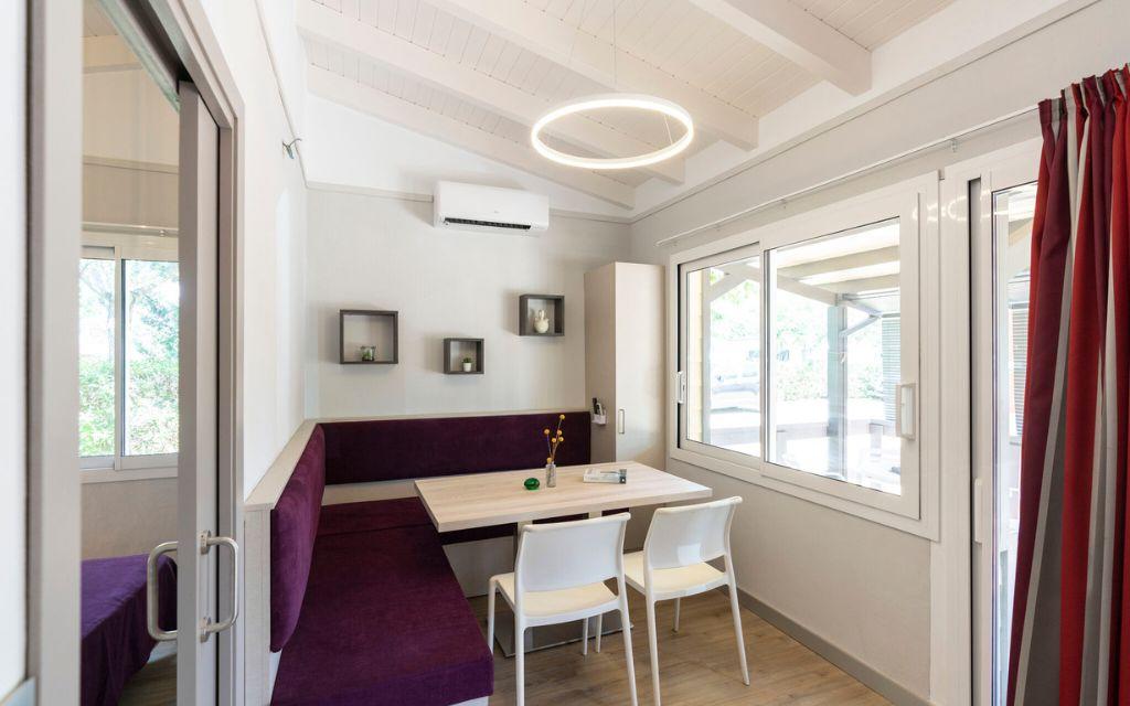 Slide Bright, air-conditioned living room with a convertible bench in the Premium Bungalows at Camping del Mar 4* in Malgrat de Mar