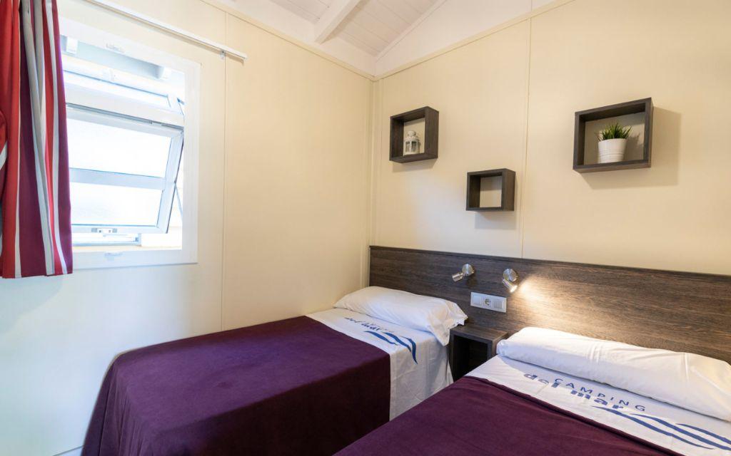 Slide Second bedroom with two single beds, ideal as a children’s room, in the Premium Bungalows at Camping del Mar 4* in Malgrat de Mar