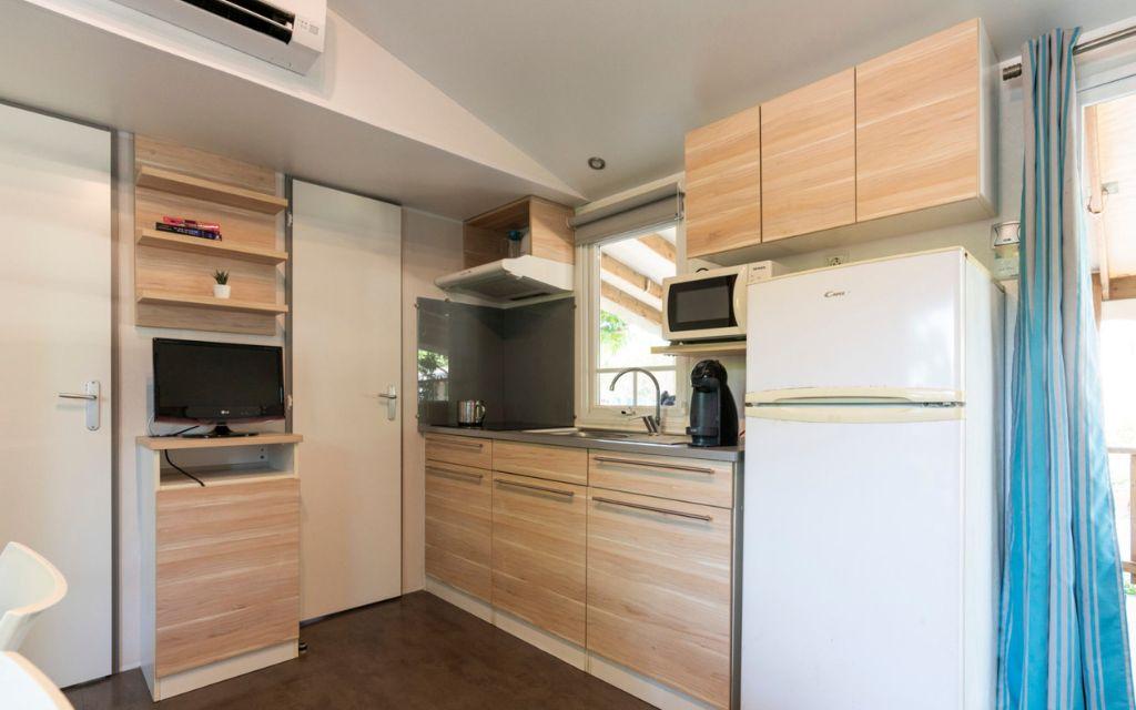 Slide Fully equipped kitchen open to the living room in a mobile home at Camping del Mar 4* in Malgrat de Mar