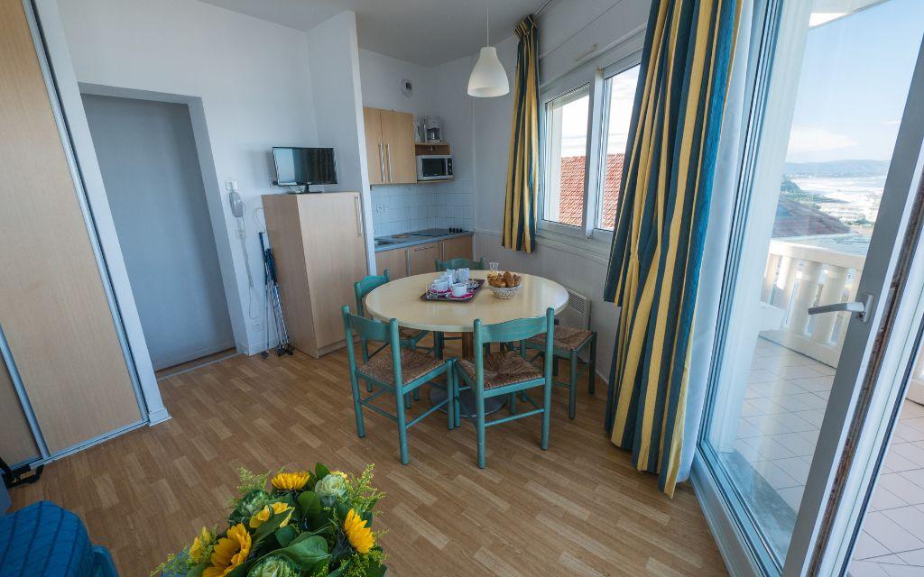 Slide Living area of a sea-view studio at the Eugénie residence in Biarritz, with dining area and access to an outdoor balcony