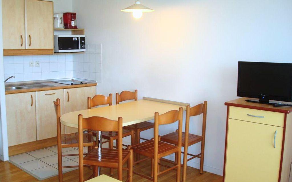 Slide Dining area with open kitchen in an apartment at the Ilbarritz residence in Bidart