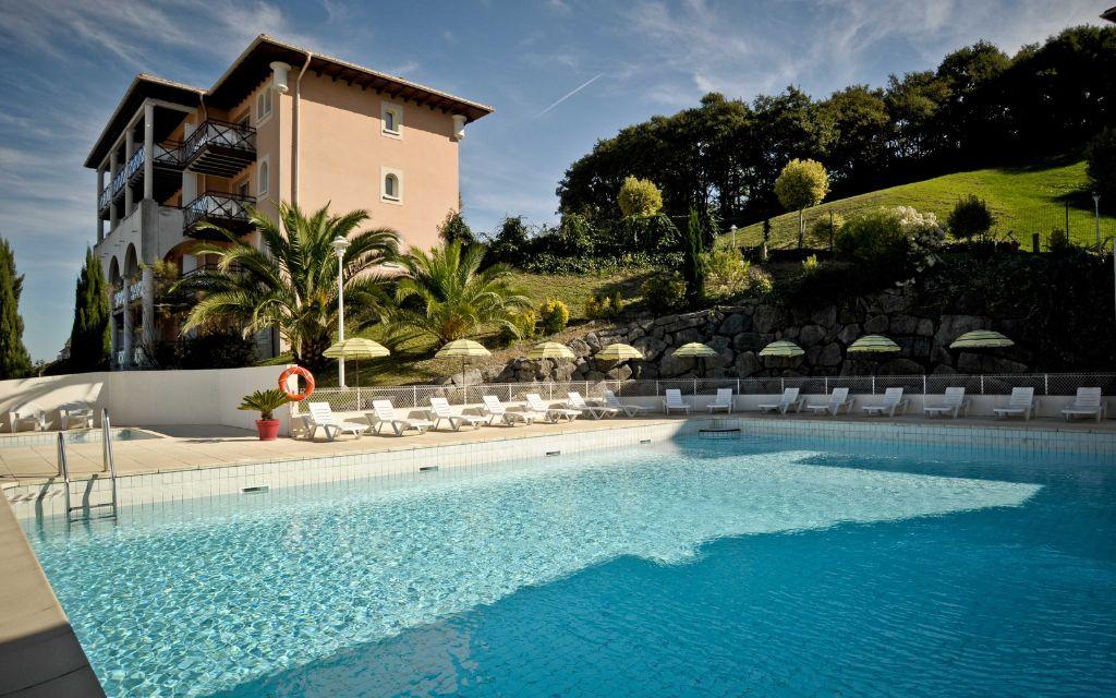 Slide Outdoor pool with sun loungers and residence buildings at Soko Eder in Ciboure