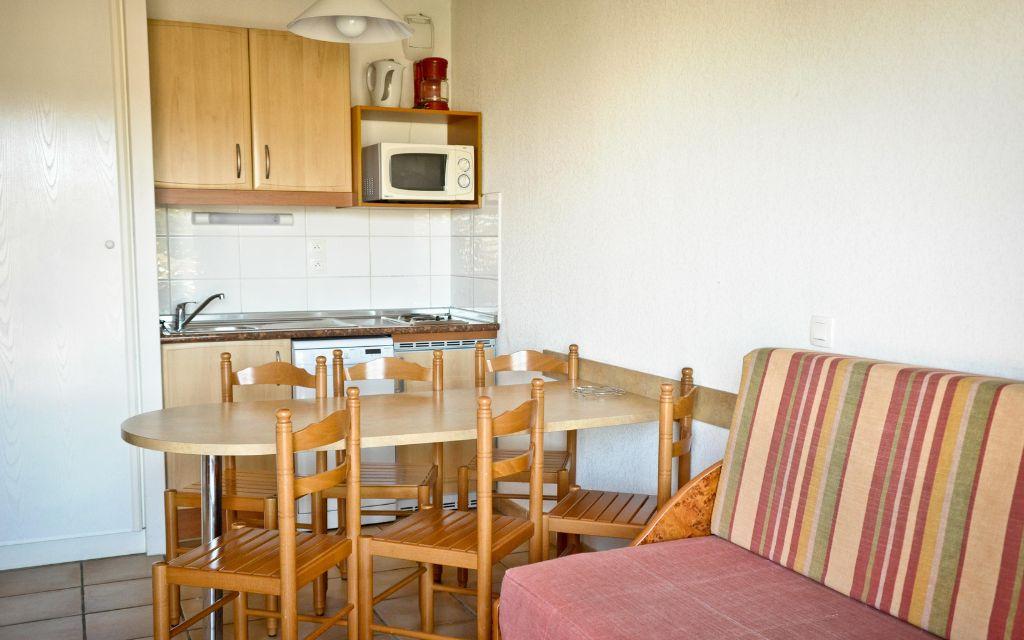 Slide Dining area with small kitchen in an apartment at the Soko Eder residence in Ciboure