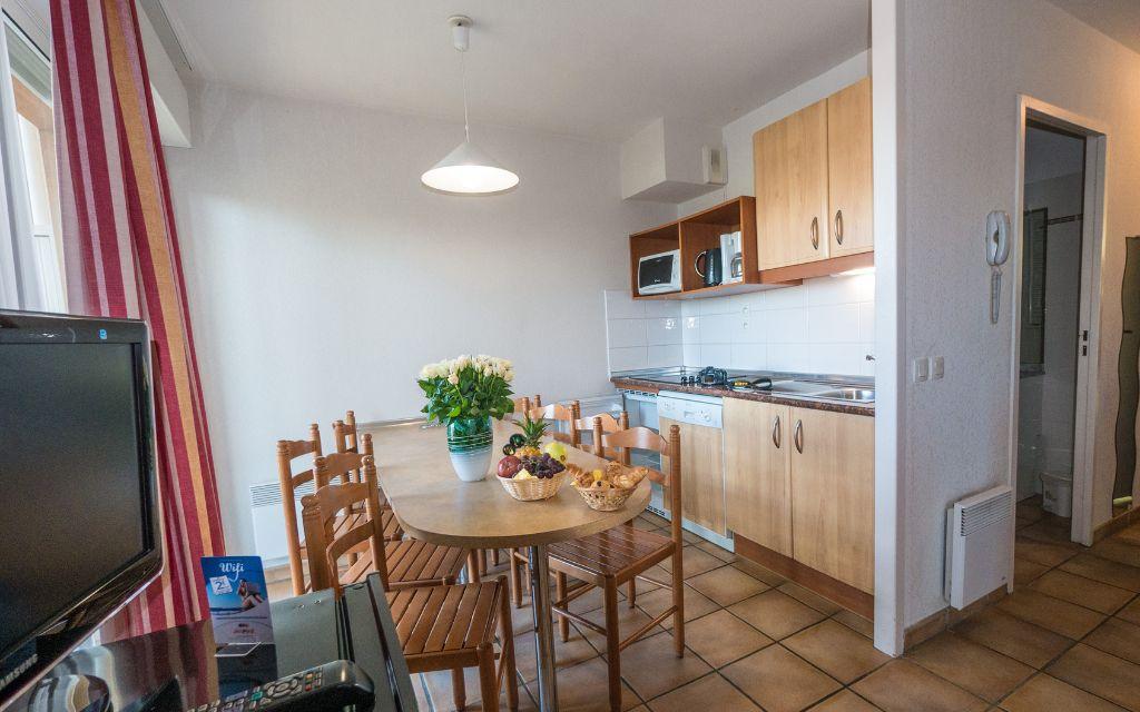 Slide Lounge and dining area with open kitchen and television in an apartment at the Soko Eder residence