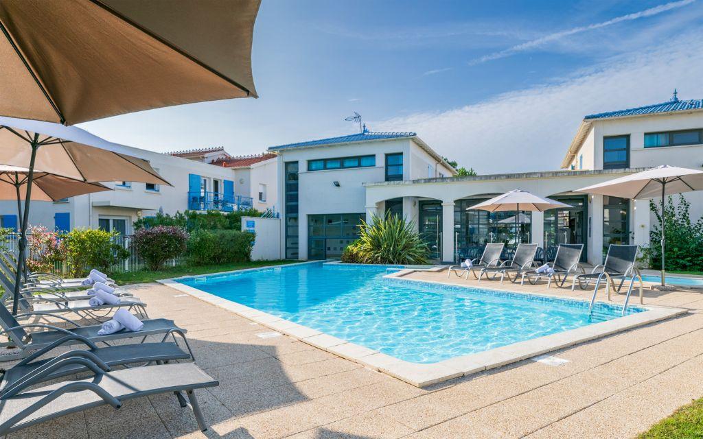 Slide Piscine extérieure non chauffée avec pataugeoire chauffée entourée de transat à la résidence Les Carrelets à Saint-Palais-sur-Mer
