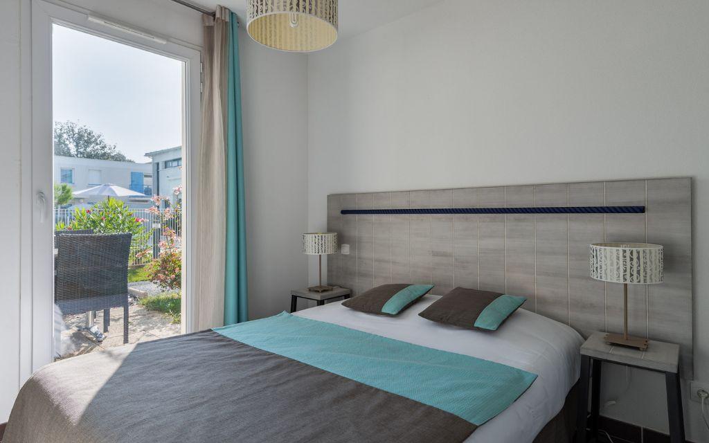 Slide Chambre double spacieuse ouverte sur un extérieur privatif dans l'un des logements Les Carrelets à Saint-Palais-sur-Mer