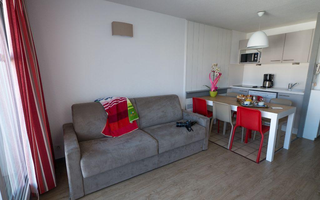 Slide Séjour ouvert avec coin salon et cuisine équipée dans un logement de la résidence Sokoburu