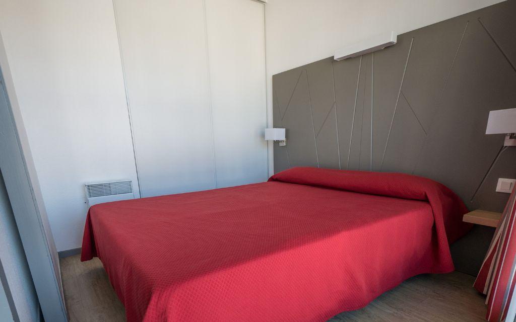 Slide Bedroom with a double bed in an apartment of the Sokoburu residence in Hendaye overlooking the patio