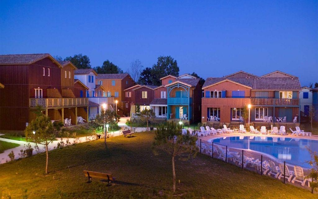Slide Night-time view of the Les Rives Marines residence and its central heated outdoor aquatic area