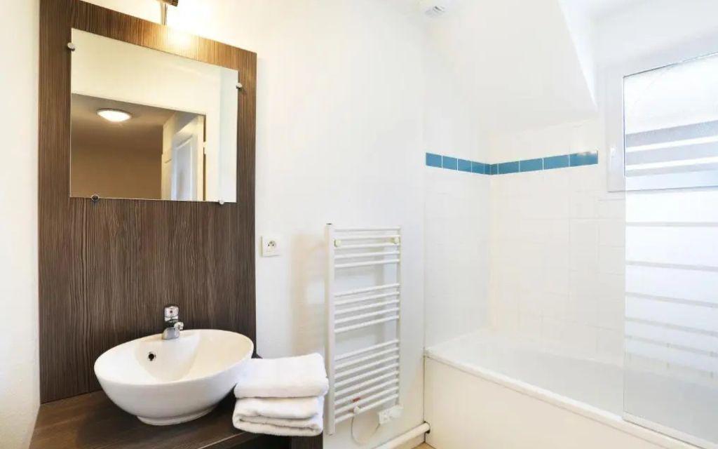 Slide Salle de bain avec baignoire et lavabo dans un logement du Domaine de la Baie à Audierne