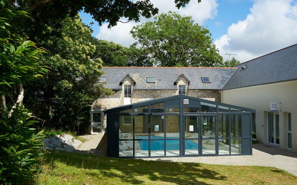 Slide Heated indoor swimming pool in a veranda at the Domaine de la Baie in Audierne