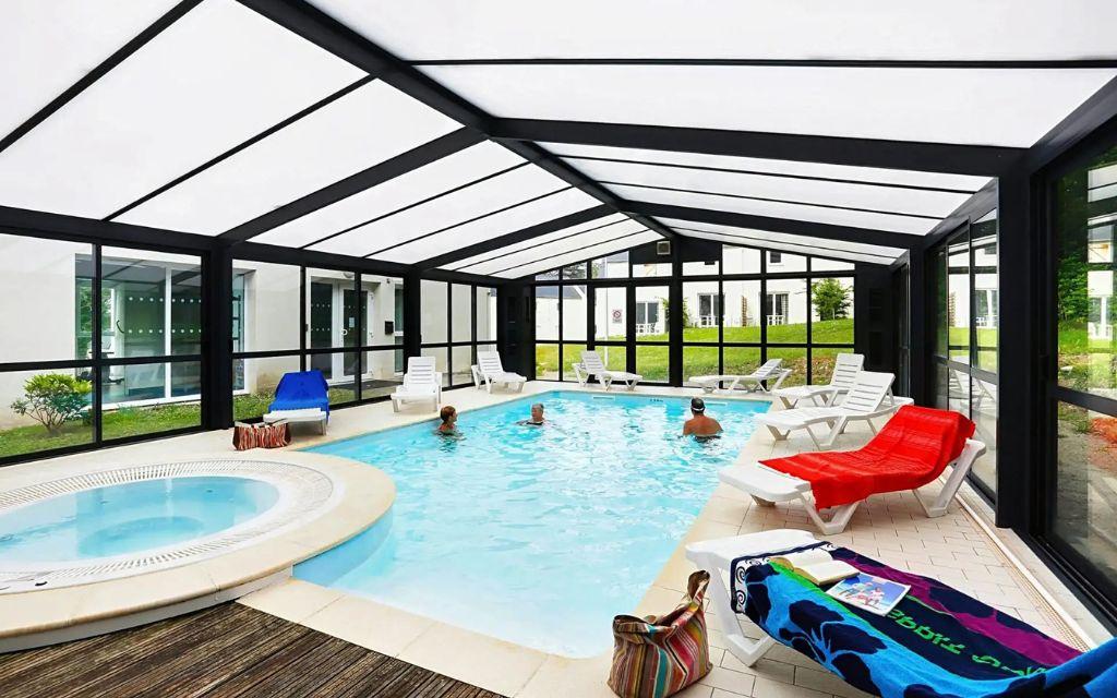 Slide Heated indoor swimming pool with jacuzzi at the Domaine de la Baie