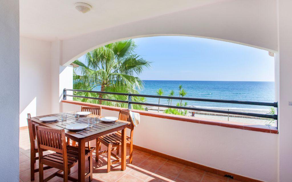 Slide Balcon ouvert avec tables et chaises et vue mer dans l'un des appartements de la résidence Sognu Di Rena à Moriani-Plage