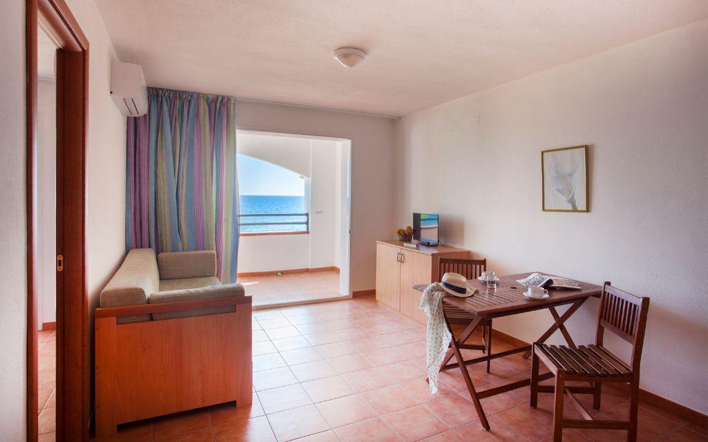 Slide Salon équipé d'une télévision et ouvert sur un balcon vue mer dans l'undes appartements de la résidence Sognu Di Rena à Moriani-Plage