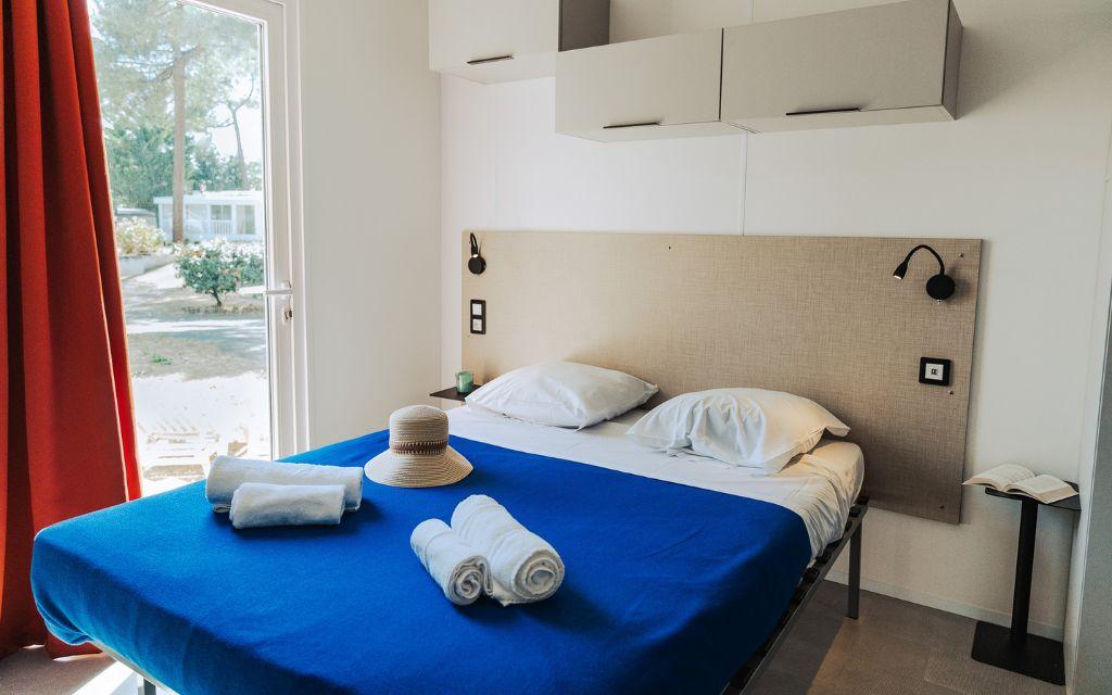 Slide Chambre avec lit double et ouverture sur le domaine dans les cottages quatre personnes au camping Tropicana à Saint-Jean-de-Monts en Vendée