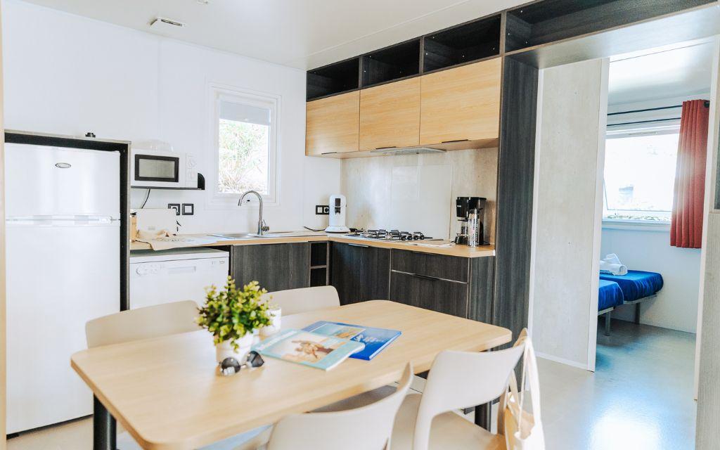 Slide Living room opening onto a fully equipped kitchen in one of the cottages at Le Tropicana Campsite in Saint-Jean-de-Monts, Vendée