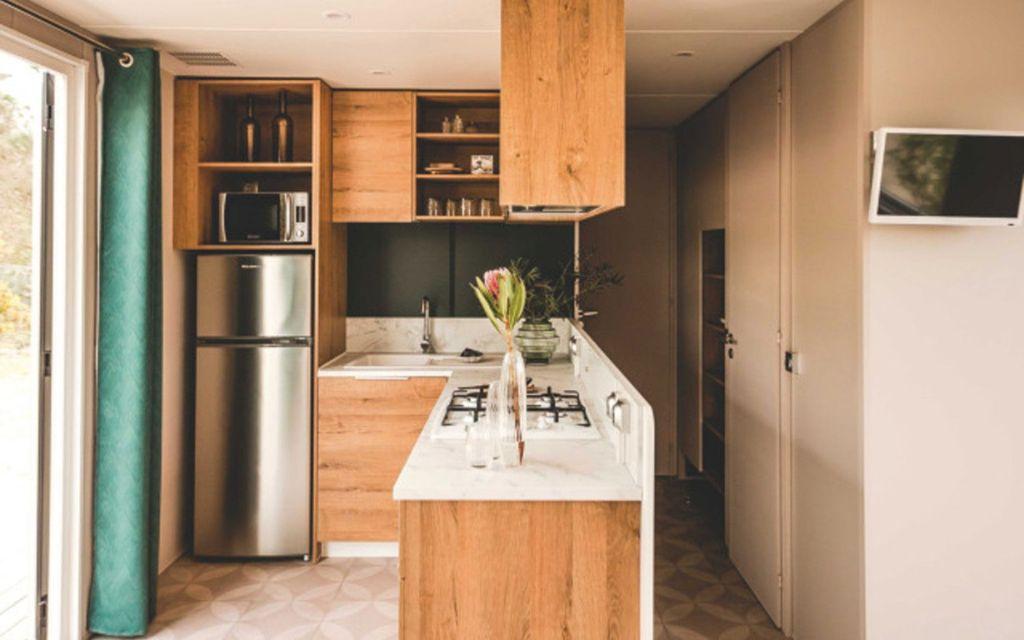 Slide Cuisine moderne équipée ouverte sur le salon dans le cottage premium 6 personnes au sein du camping les places dorées*****