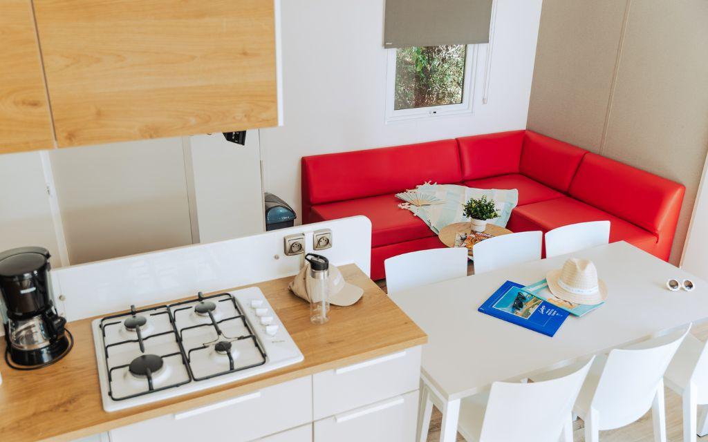 Slide Living space comprising a lounge and a fitted kitchen in the six-person cottages at Tropicana Campsite in Saint-Jean-de-Monts, Vendée