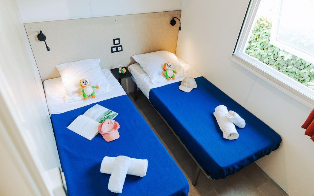 Slide Bedroom with two single beds, ideal as a children’s room, in the four-person cottages at Tropicana Campsite in Saint-Jean-de-Monts, Vendée