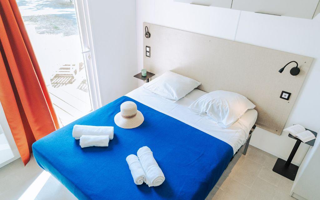 Slide Bedroom with a double bed and included towels in a cottage at Les Places Dorées***** campsite