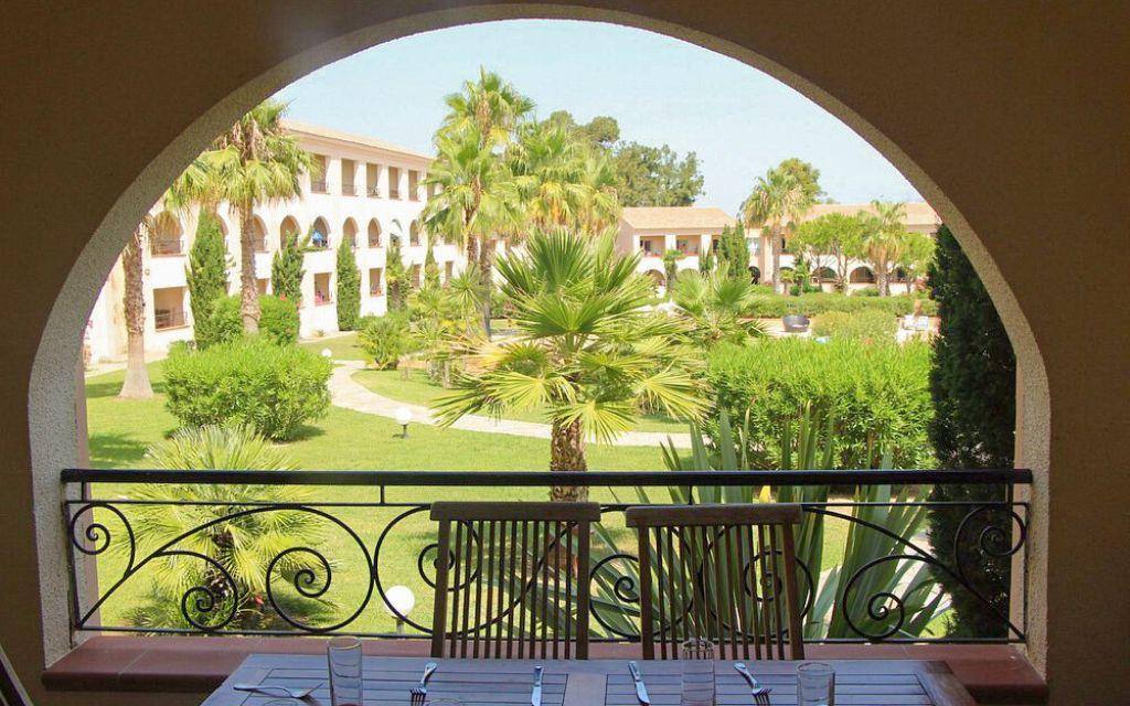 Slide Vue sur le patio fleuri intérieur de la résidence Sognu di Mare depuis l'un des balcons de la résidence à Linguizzetta