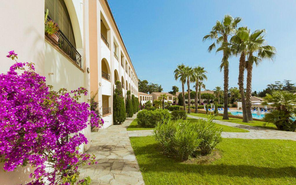 Slide Bougainvillea-covered building with lush green gardens at the Sognu di Mare residence in Linguizzetta