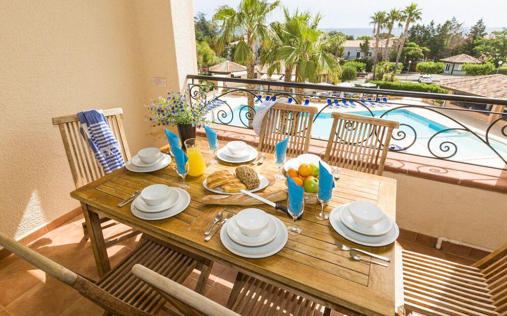 Slide Furnished balcony with table and chairs, ideal for enjoying meals sheltered from the heat at the Sognu di Mare residence in Linguizzetta