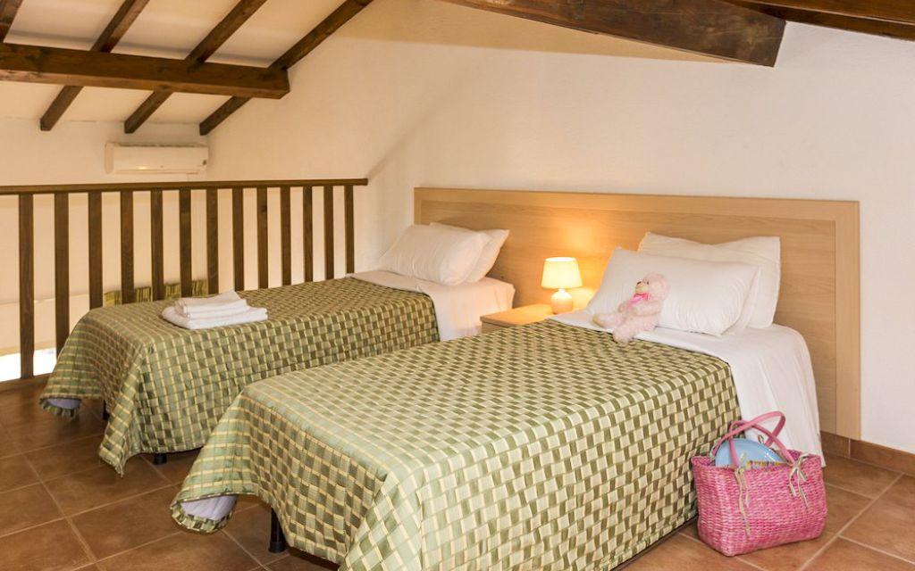 Slide Mezzanine bedroom with two single beds, perfect for a children’s room, in the apartments of the Sognu di Mare residence in Linguizzetta