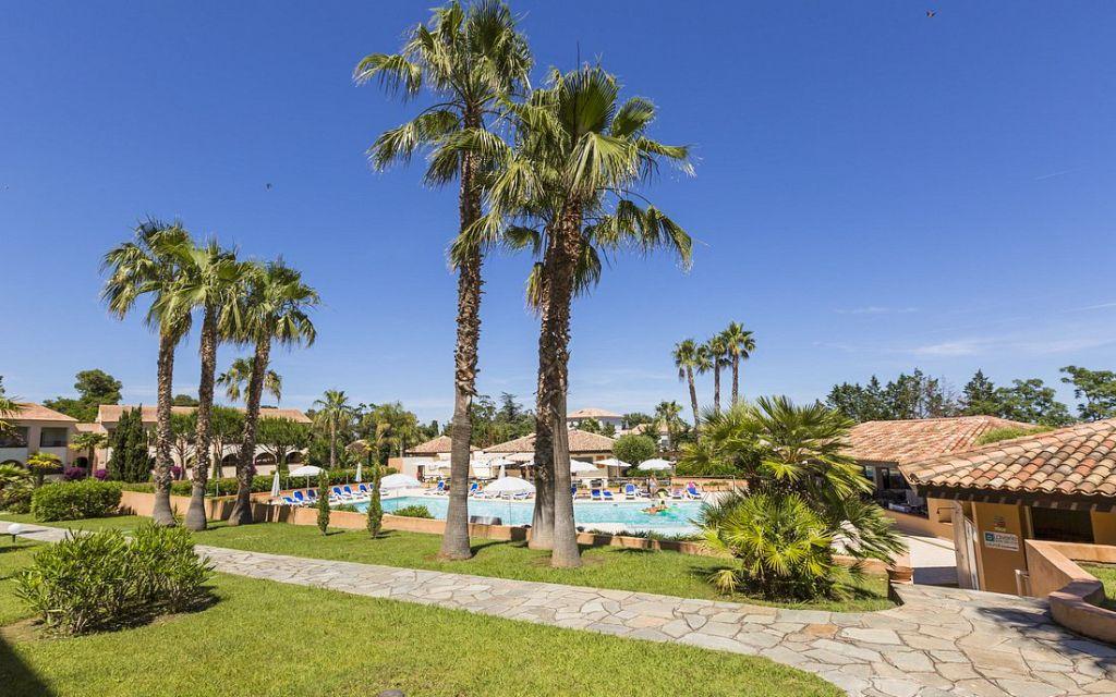 Slide Attractive aquatic area surrounded by palm trees, offering a calm and relaxing atmosphere at the Sognu di Mare residence in Linguizzetta