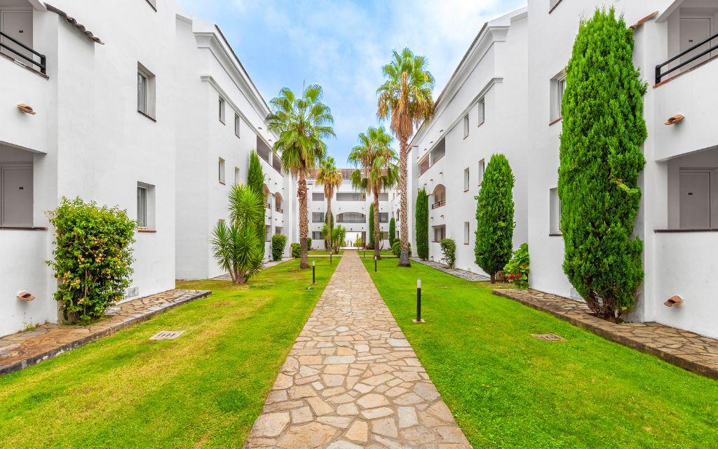 Slide Outdoor patio with lush Mediterranean-style gardens at the Sognu Di Rena residence in Moriani-Plage