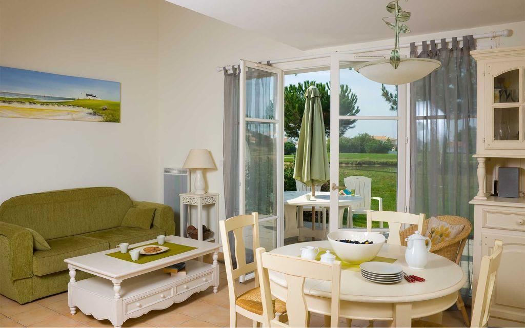 Slide Living room of a Fontenelles house with lounge and dining areas, offering views of and direct access to the golf course